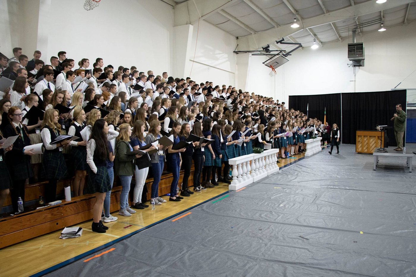 A massed choir of students from University-Model® member schools performing together on risers